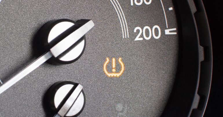 Tyre pressure sensor warning light on car dashboard